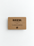 Kraftpapieren cadeaubon van BREW. Coffee met het logo, de tekst 'Cadeaubon' en een koffieboon-icoon, tegen een lichte achtergrond."
